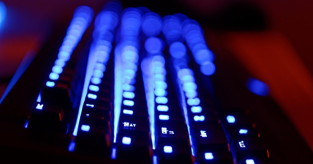青色LEDバックライトが光るゲーミングキーボードのクローズアップ
