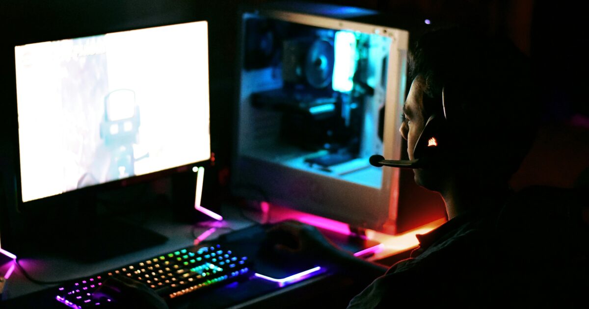 RGBキーボードでゲームをプレイ中のゲーマーと自作PCセットアップ