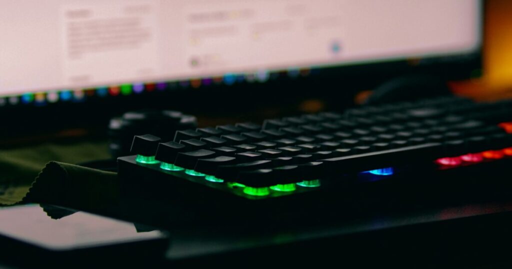 バックライト付きメカニカルキーボードとモニターのクローズアップ