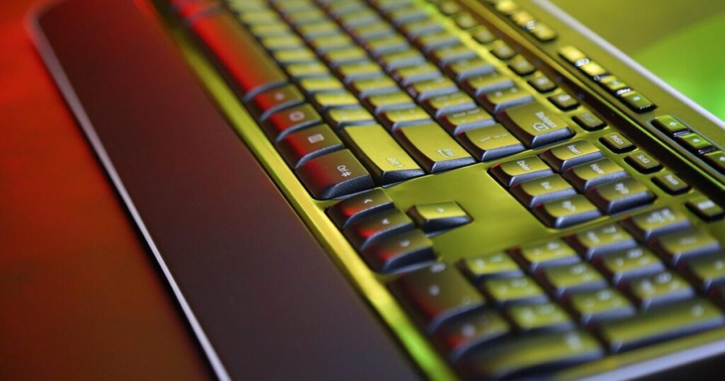光沢のある黒と緑のメカニカルキーボードのクローズアップ