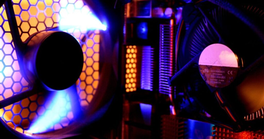 青とオレンジのLEDが点灯したPCケース内の冷却ファンとヒートシンク