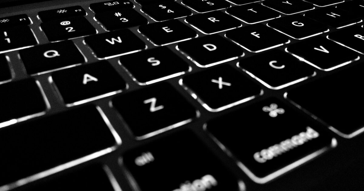 バックライトが点灯したノートパソコンのキーボードクローズアップ